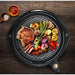 Various foods of meat and vegetable grilled on the grill surface.